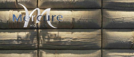 A textured wall with the 'Mercure Hotels' logo.