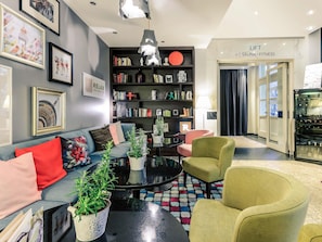 Una sala de estar moderna con un sofá, sillones, una mesa de centro y una estantería.
