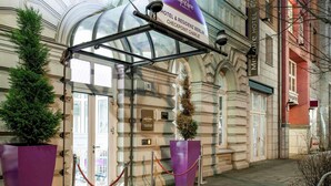 A hotel entrance with a marquee sign, a glass canopy, and a classical building facade. - Mercure Hotel & Residenz Checkpoint Charlie (Berlin)