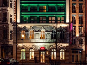 A building with a classic architectural style, featuring arched windows and a prominent entrance with a red awning. - Mercure Hotel & Residenz Checkpoint Charlie (Berlin)