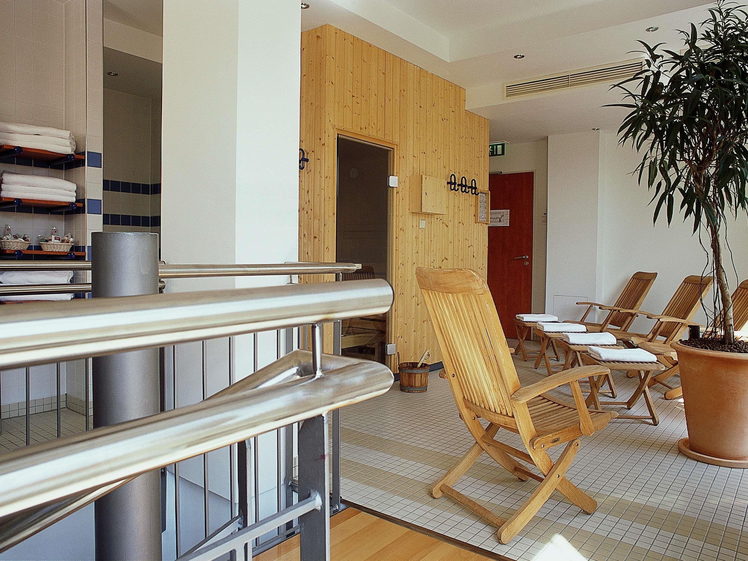 A spa area with wooden chairs, a reception desk, and a potted plant.