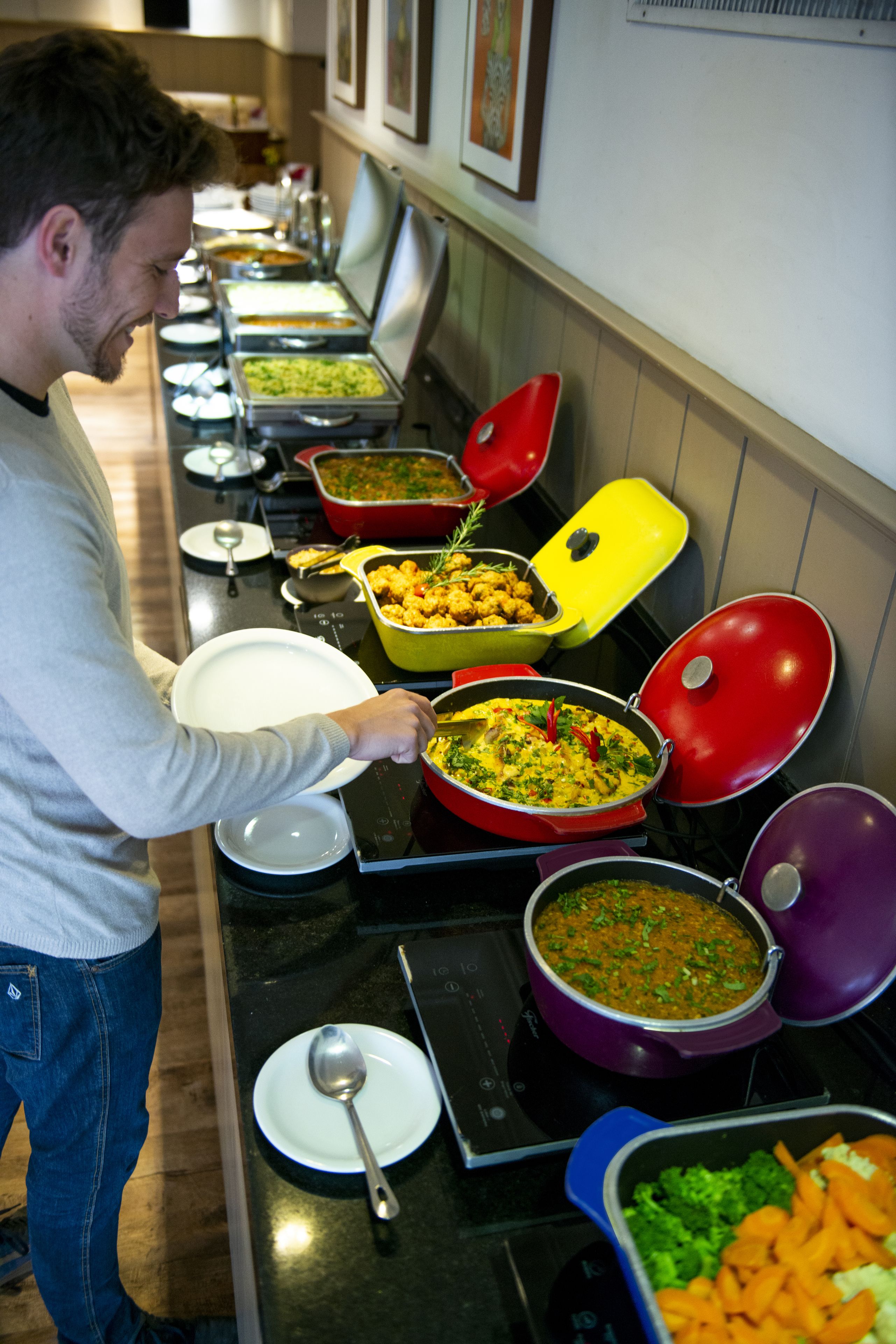 Un buffet proposant une variété de plats présentés dans des récipients colorés.