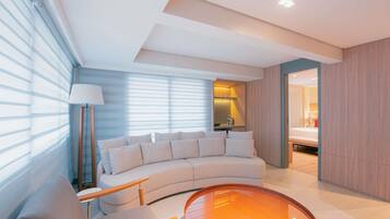 A modern living room with a curved sofa, a round coffee table, and a lamp.