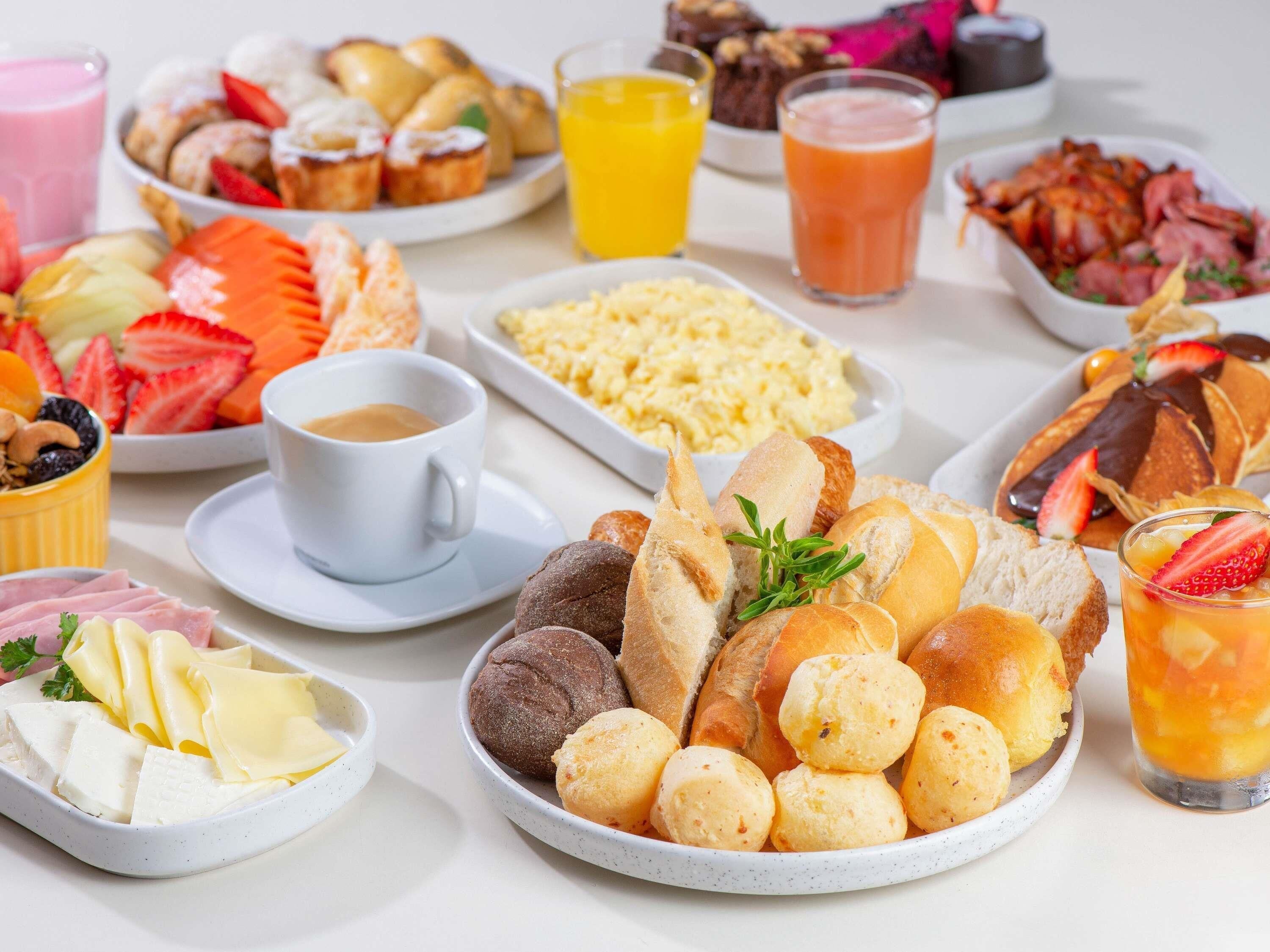 A variety of breakfast foods including bread, pastries, and fruits.