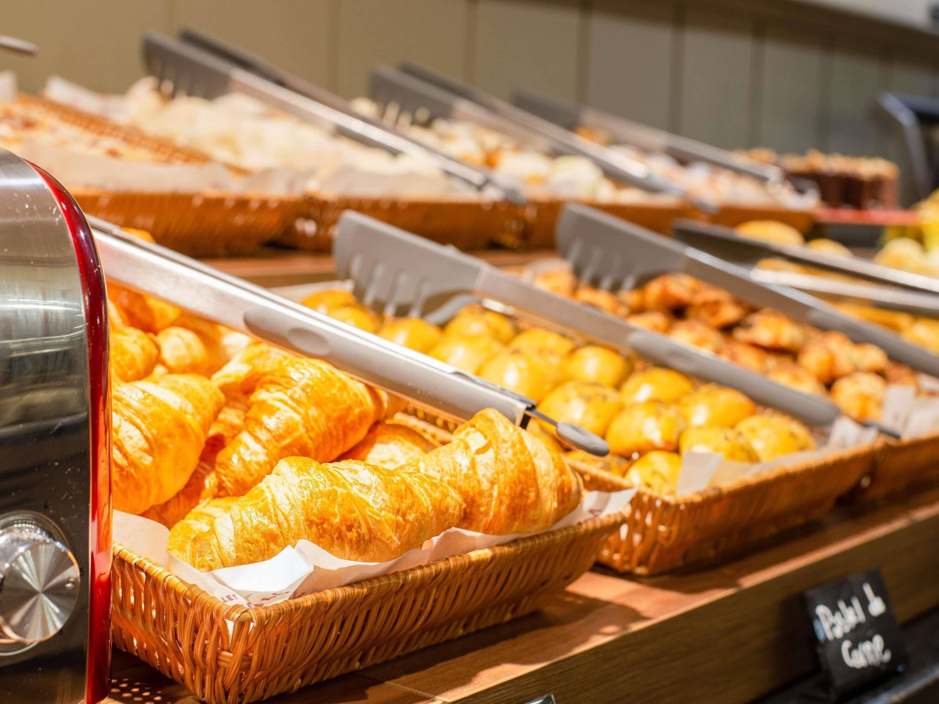 A buffet with various food items, including croissants and other baked goods.