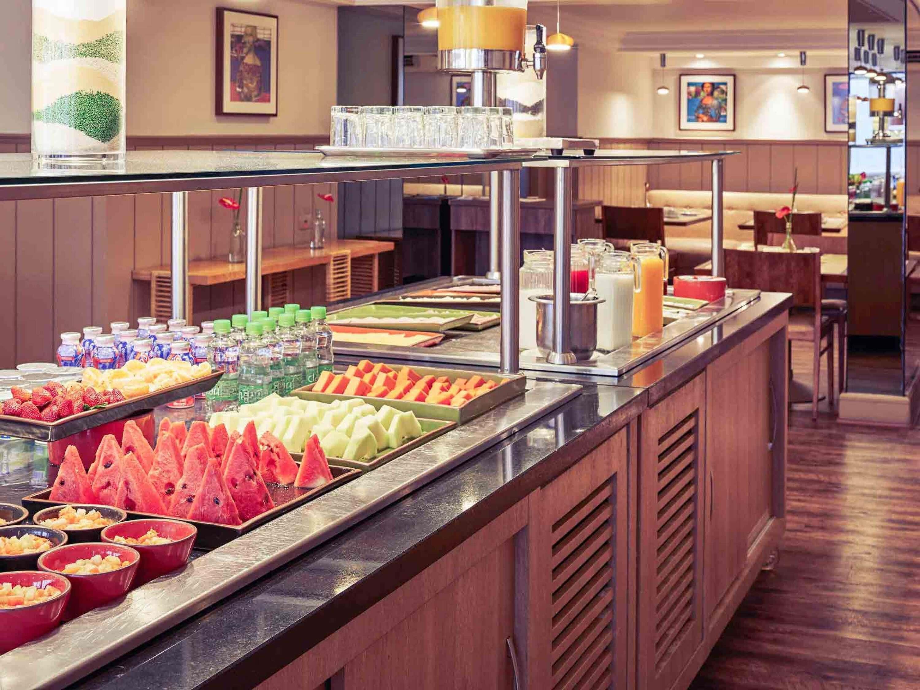Un buffet proposant une variété de fruits, de boissons et une machine à café.