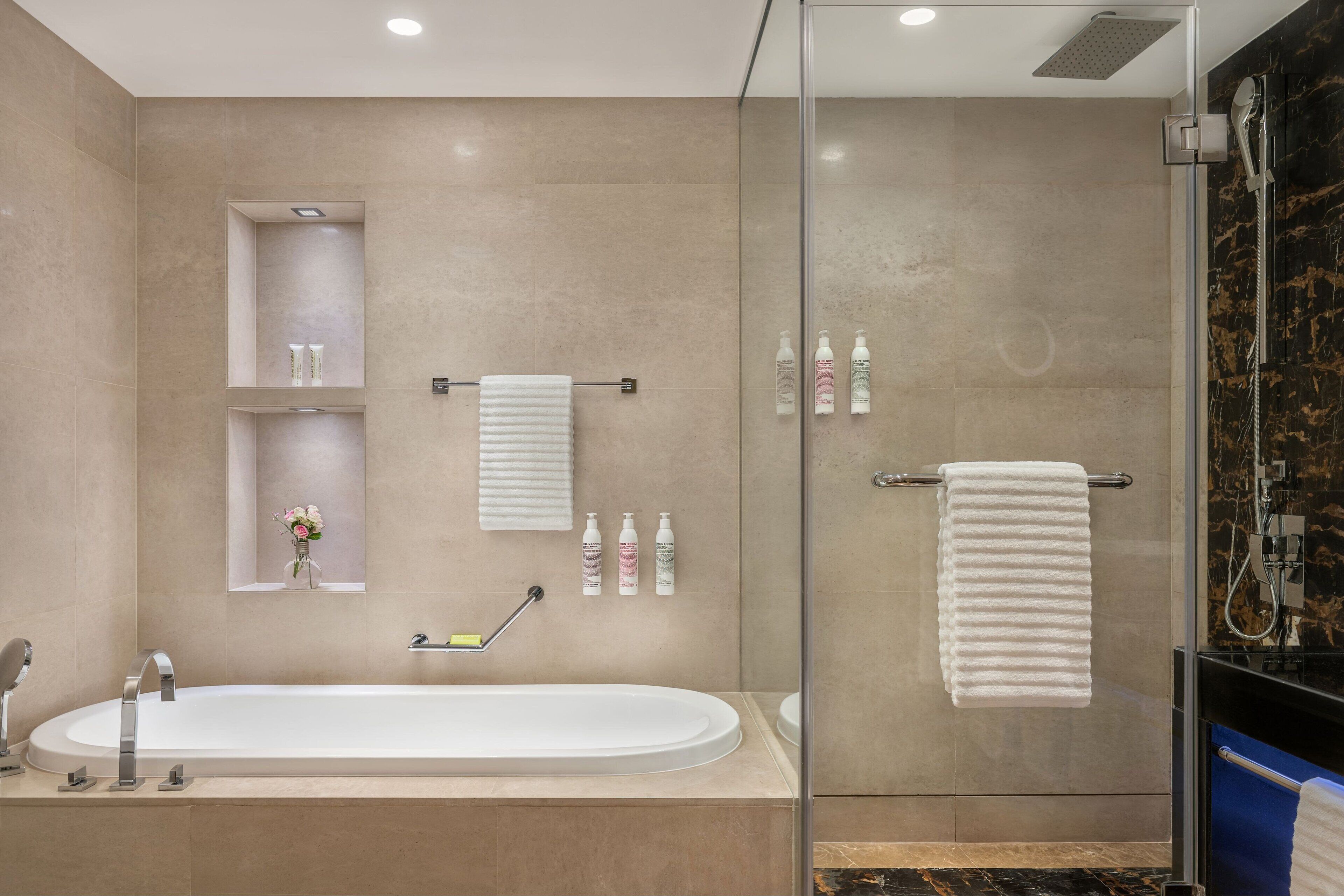 Une salle de bain moderne avec une baignoire sur pieds, une douche à parois de verre et un meuble-lavabo avec un miroir.