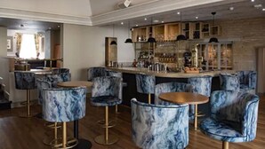 Uma área de bar com cadeiras de padrão marmorizado e um balcão.