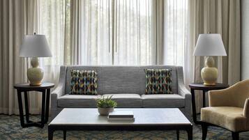 A living room with a sofa, two armchairs, a coffee table, and two lamps.