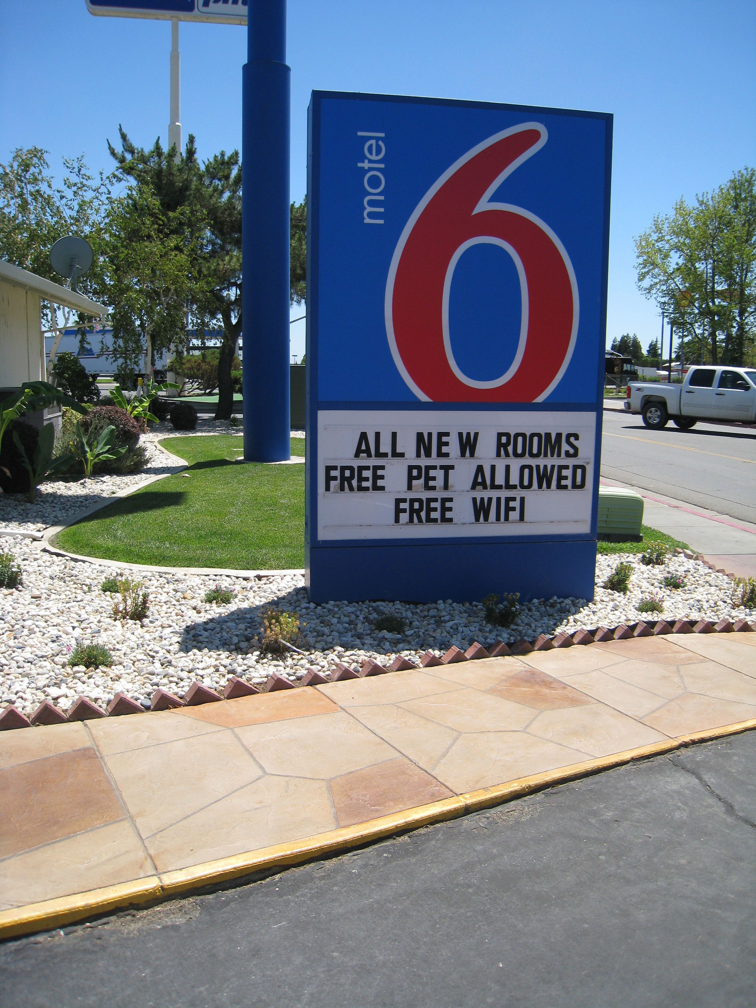 A motel sign advertising all new rooms, free pet allowance, and free WiFi.
