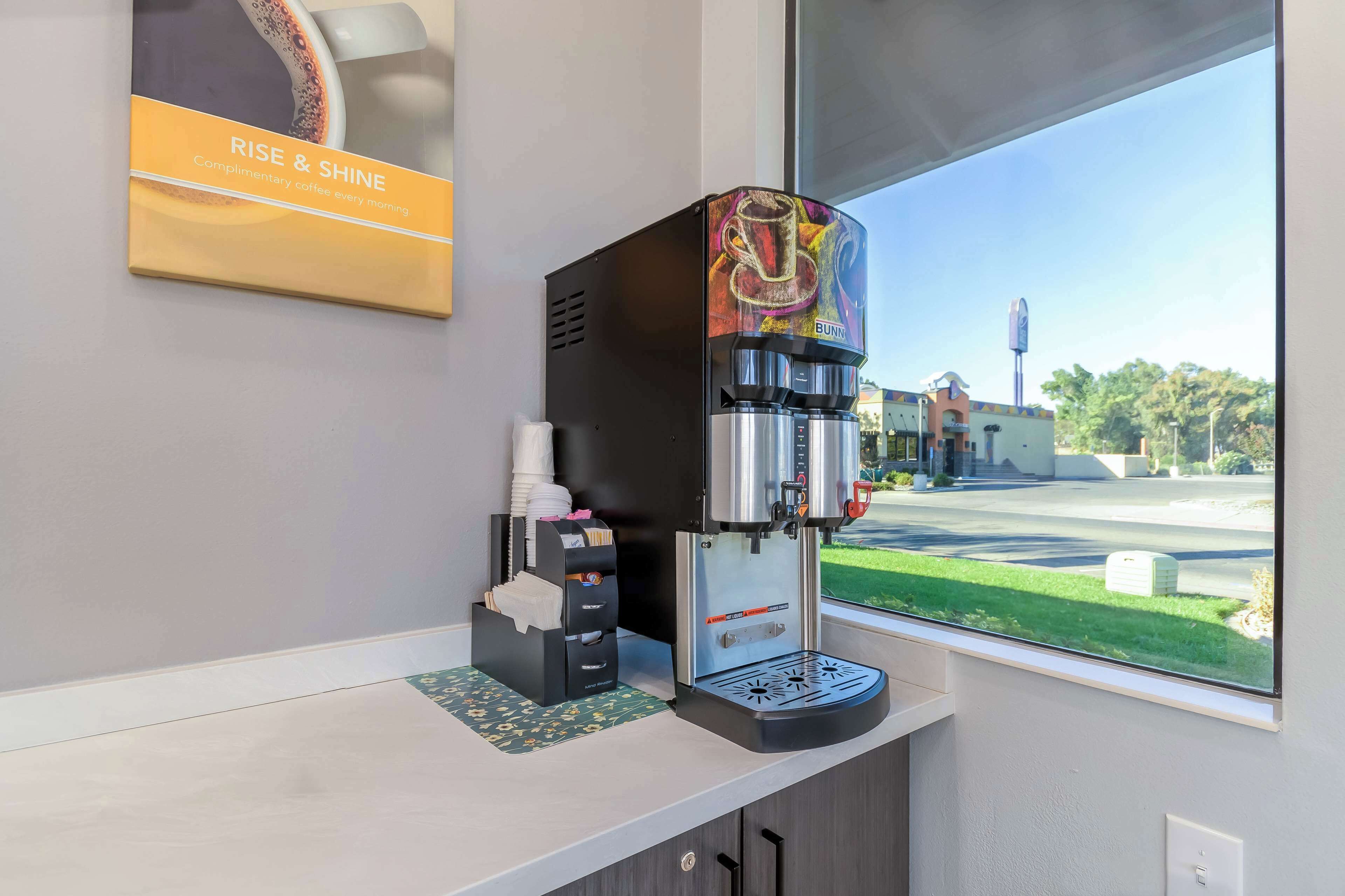 A coffee machine with a Bunn logo, a coffee cup, and a tissue box on a counter.
