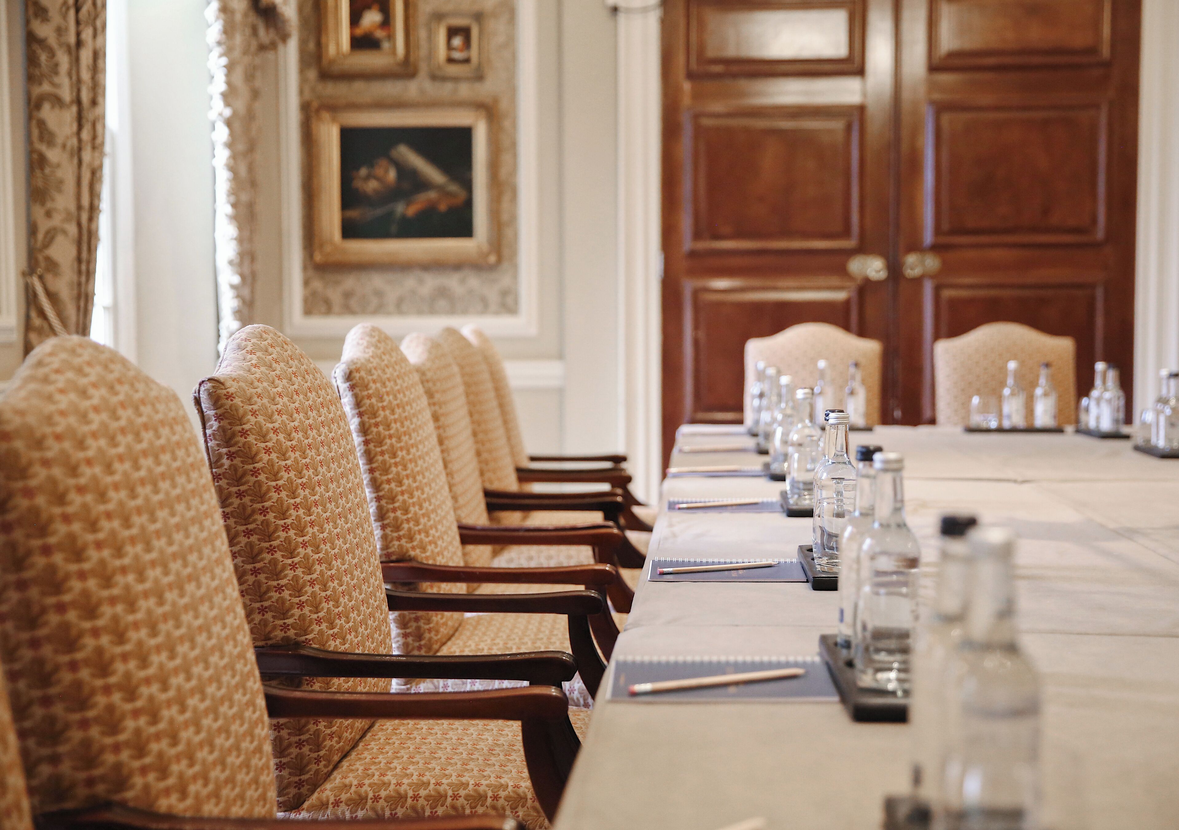 A conference room with a long table, chairs, and water bottles.