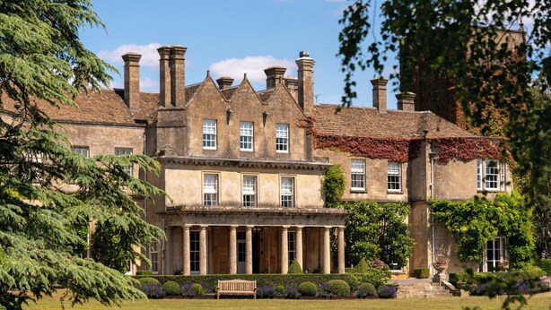 A large, historic building with a symmetrical facade, columns at the entrance, and a well-maintained lawn. - Lucknam Park, Emblems Collection (Chippenham)