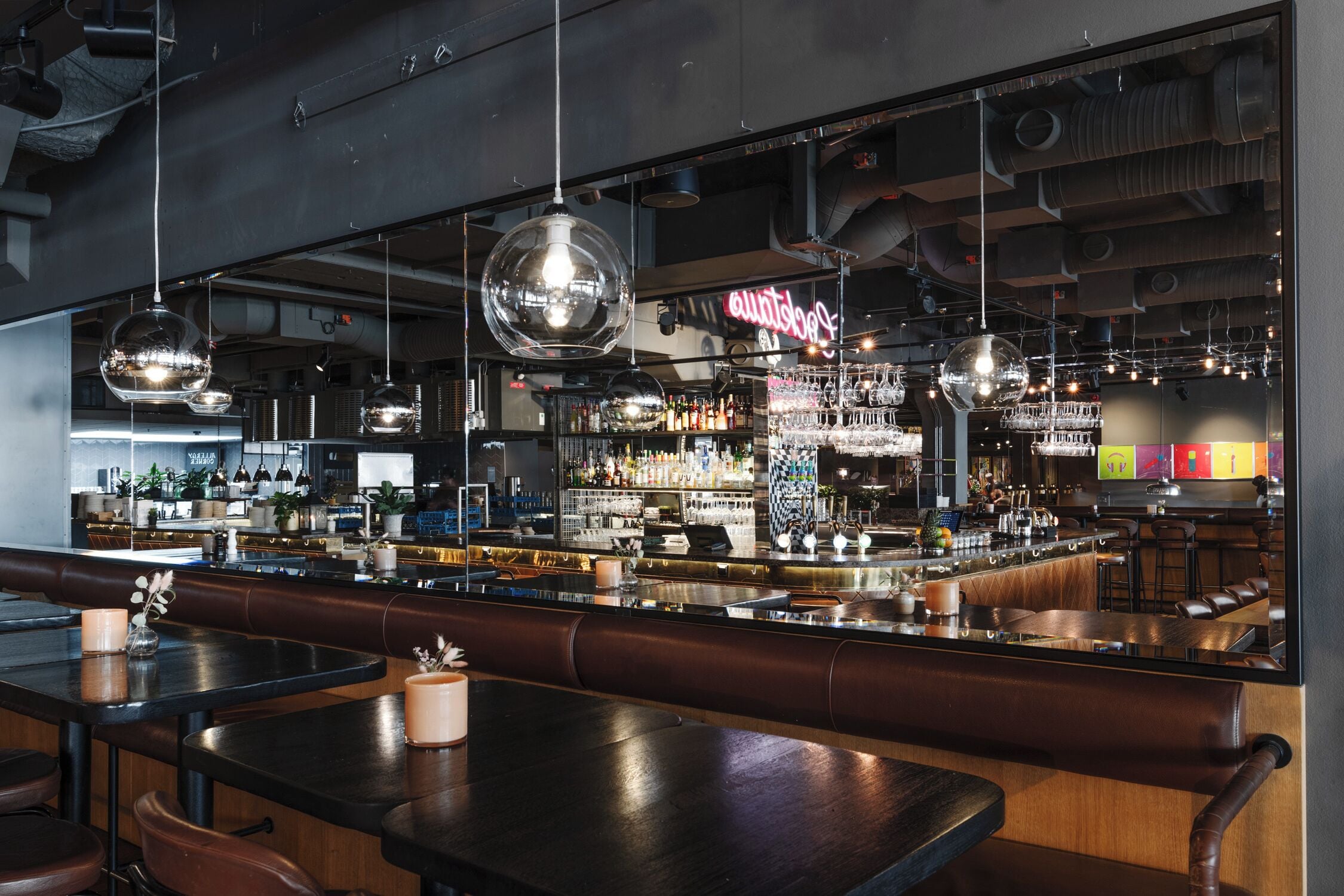 A bar area with multiple seating options, including booths and tables, and a bar counter with a variety of bottles and glasses.