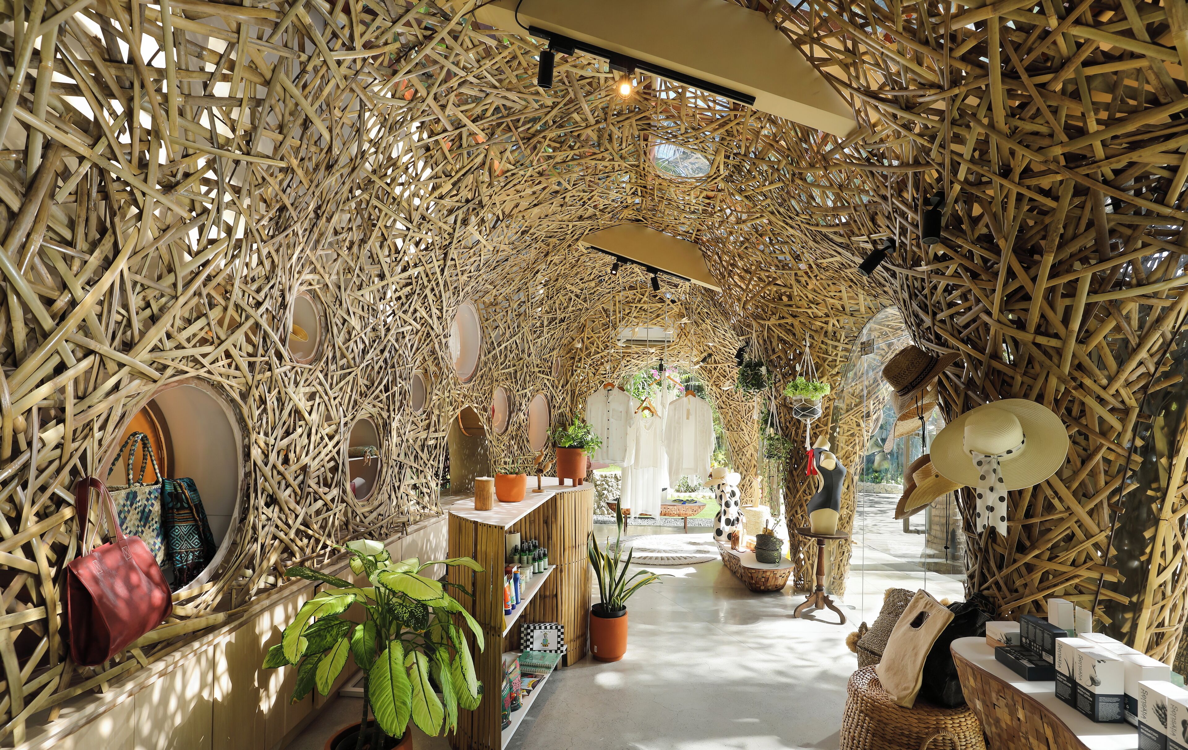 An interior with a bamboo archway, shelves with items, and a central pathway.