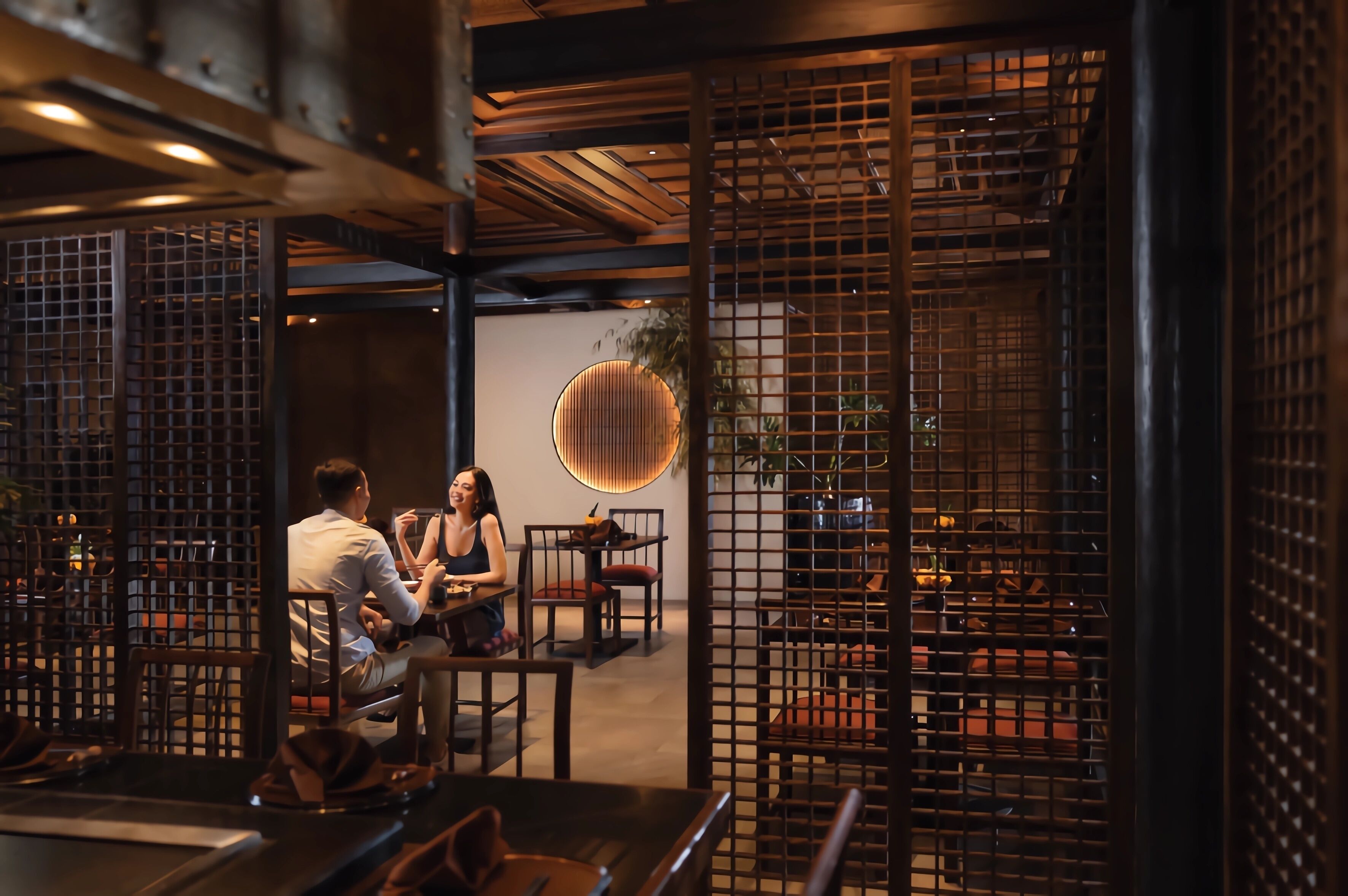 A modern dining area with wooden furniture and a decorative wall.
