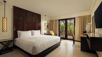 A modern hotel room with a large bed, a desk, and a balcony with curtains.