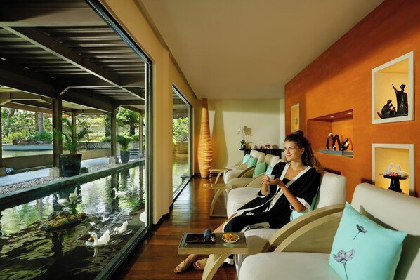 A spa area with a water feature, seating, and artwork on the walls.