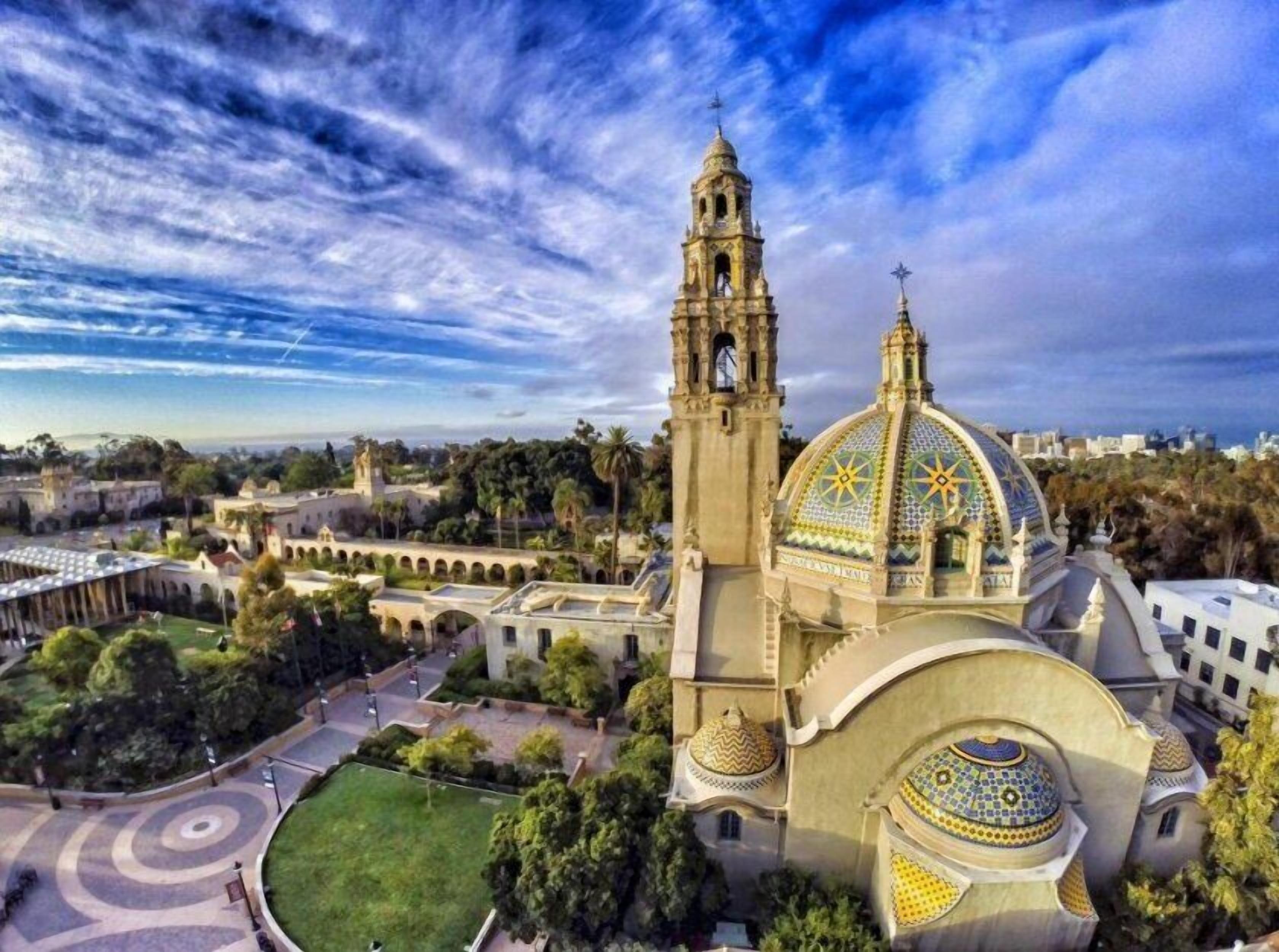 A historic building with a prominent dome and bell tower, surrounded by a well-maintained courtyard and greenery.