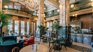 A spacious lobby with multiple seating areas, a bar, and a staircase connecting different levels.