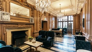 A luxurious lobby with a grand fireplace, elegant chandeliers, and plush seating areas.