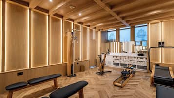 A wooden interior with benches, exercise equipment, and a counter with towels.