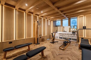 A wooden interior with benches, exercise equipment, and a counter with towels.