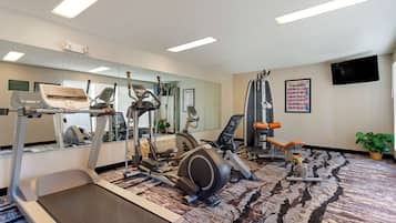 A gym with treadmills, elliptical machines, and weight equipment.