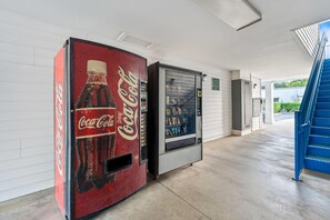 Een gang met een Coca-Cola automaat en een drankdispenser.
