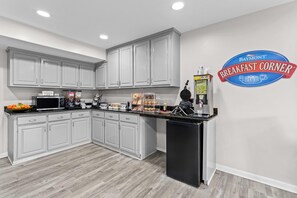 Una cocina moderna con armarios blancos, encimera negra y una zona de desayuno.