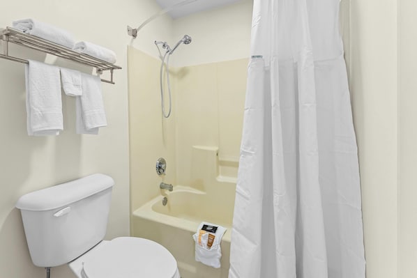 Un baño con inodoro, ducha y toallero.