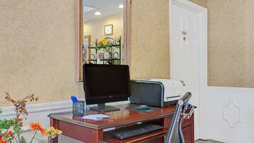 A reception desk with a computer, printer, and keyboard.