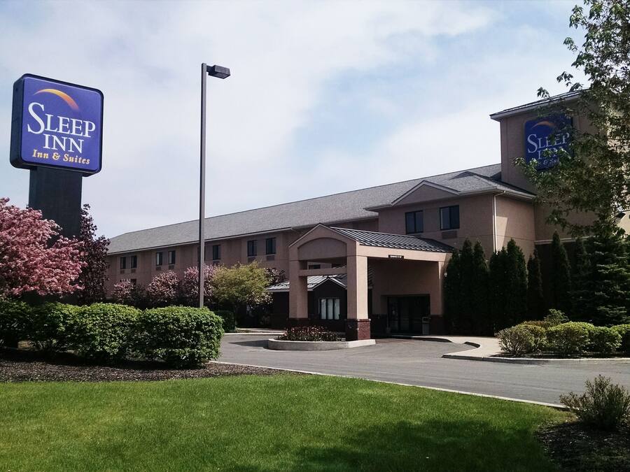 A Sleep Inn & Suites building with a parking lot and landscaped areas.