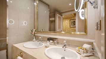 Un baño con dos lavamanos, un espejo grande y una ducha.