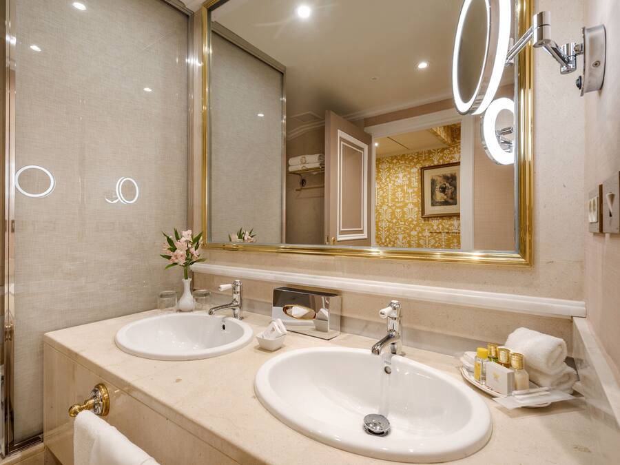 Un baño con dos lavamanos, un espejo grande y una ducha.