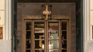A grand entrance with a wrought iron gate, a chandelier, and a set of double doors. - Relais & Châteaux Hotel Orfila (Madrid)