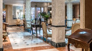 A spacious lobby with marble flooring, a central dining area, and ornate columns. - Relais & Châteaux Hotel Orfila (Madrid)