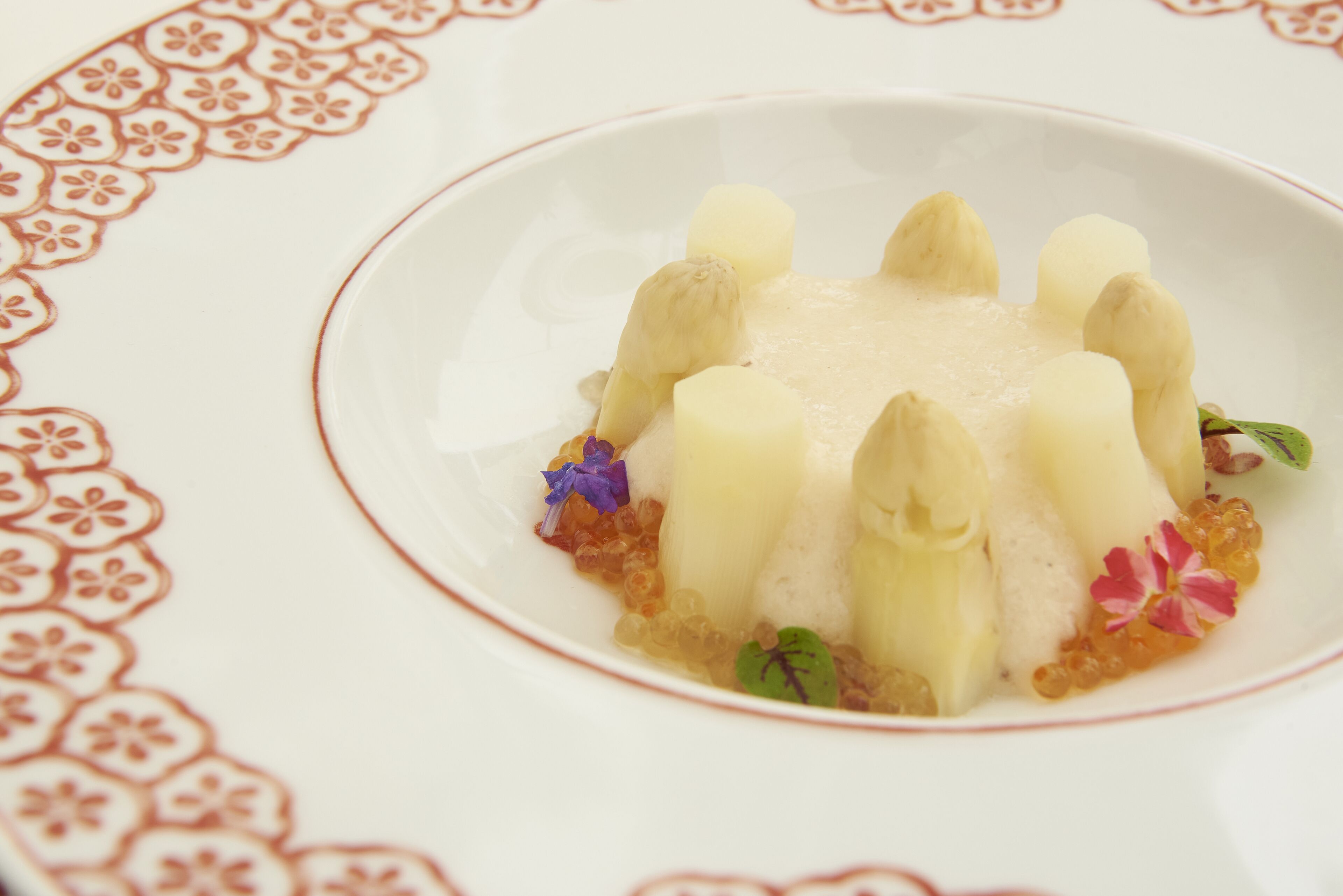 A dessert on a white plate with a floral pattern border.