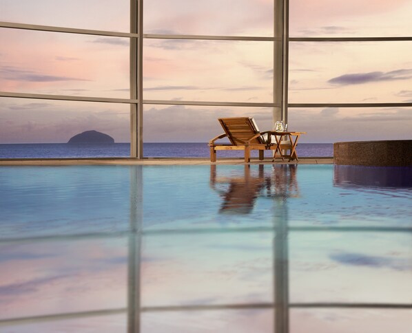 Una piscina techada, sillones reclinables de piscina