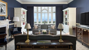 A living room with a fireplace, a sofa, a coffee table, and a bookshelf. - Trump Turnberry (Girvan)