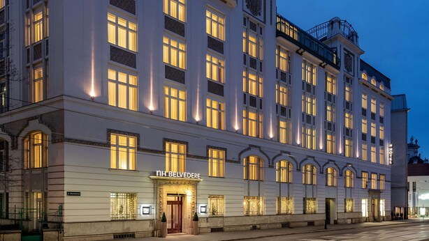 Un hotel histórico con una fachada clásica, varios pisos y una entrada destacada.