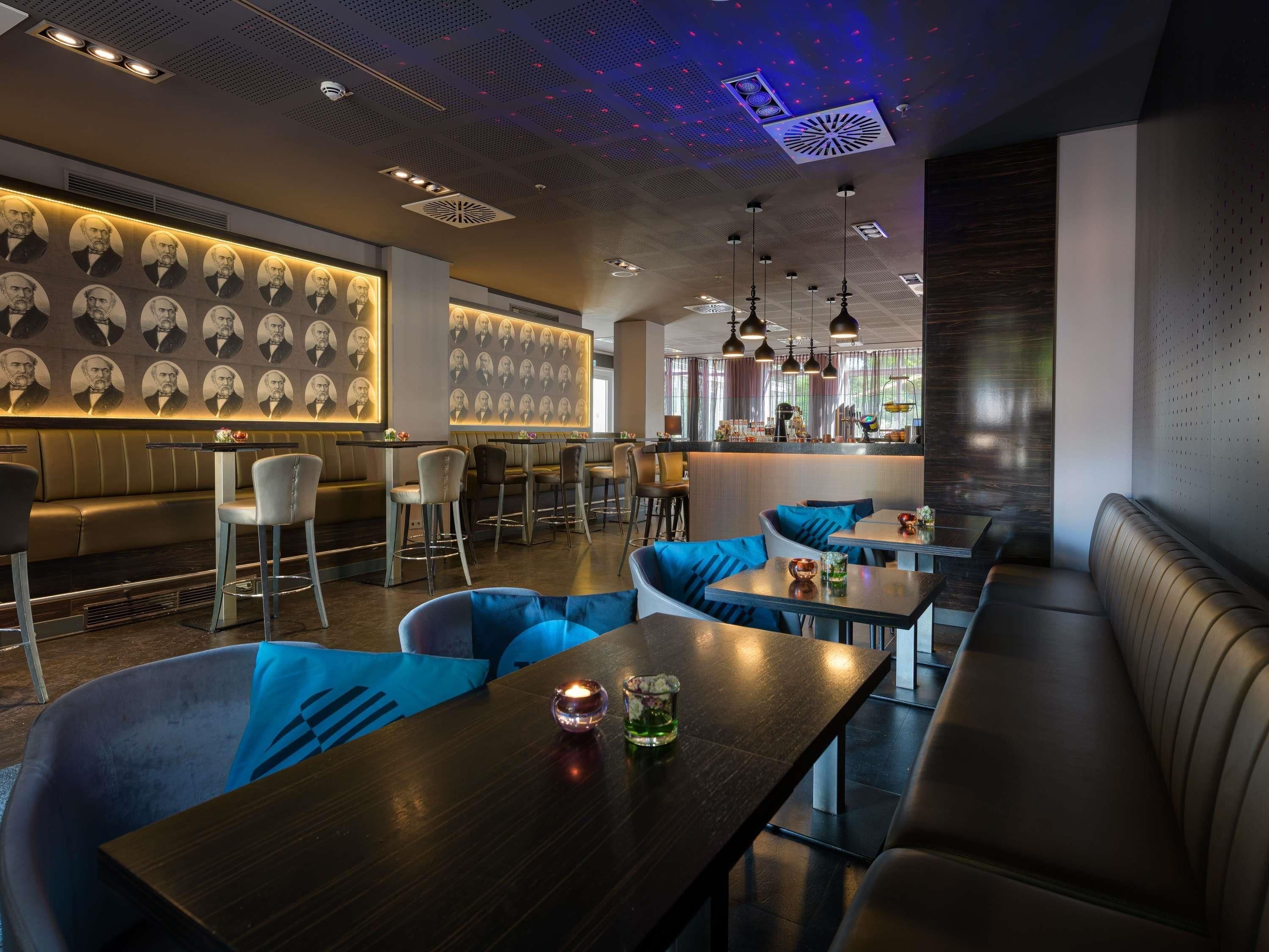 Un interior de restaurante moderno con una zona de bar, asientos y una pared con diseño.