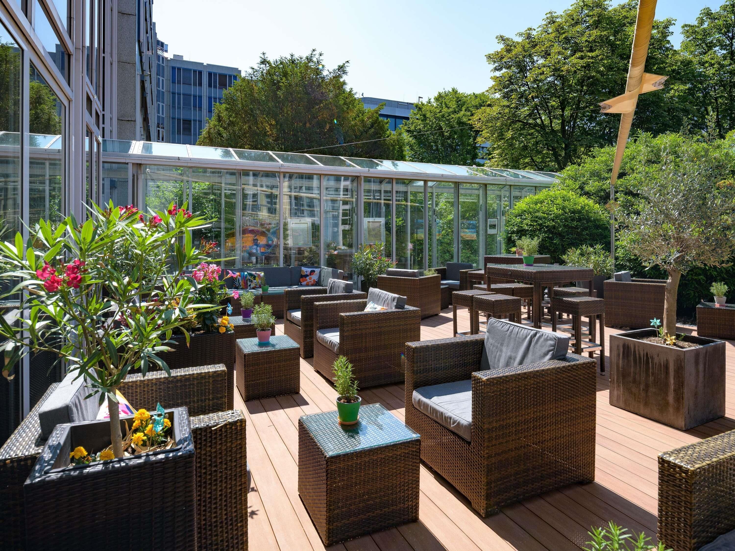 Un espace extérieur aménagé avec des meubles en osier et des plantes en pot.