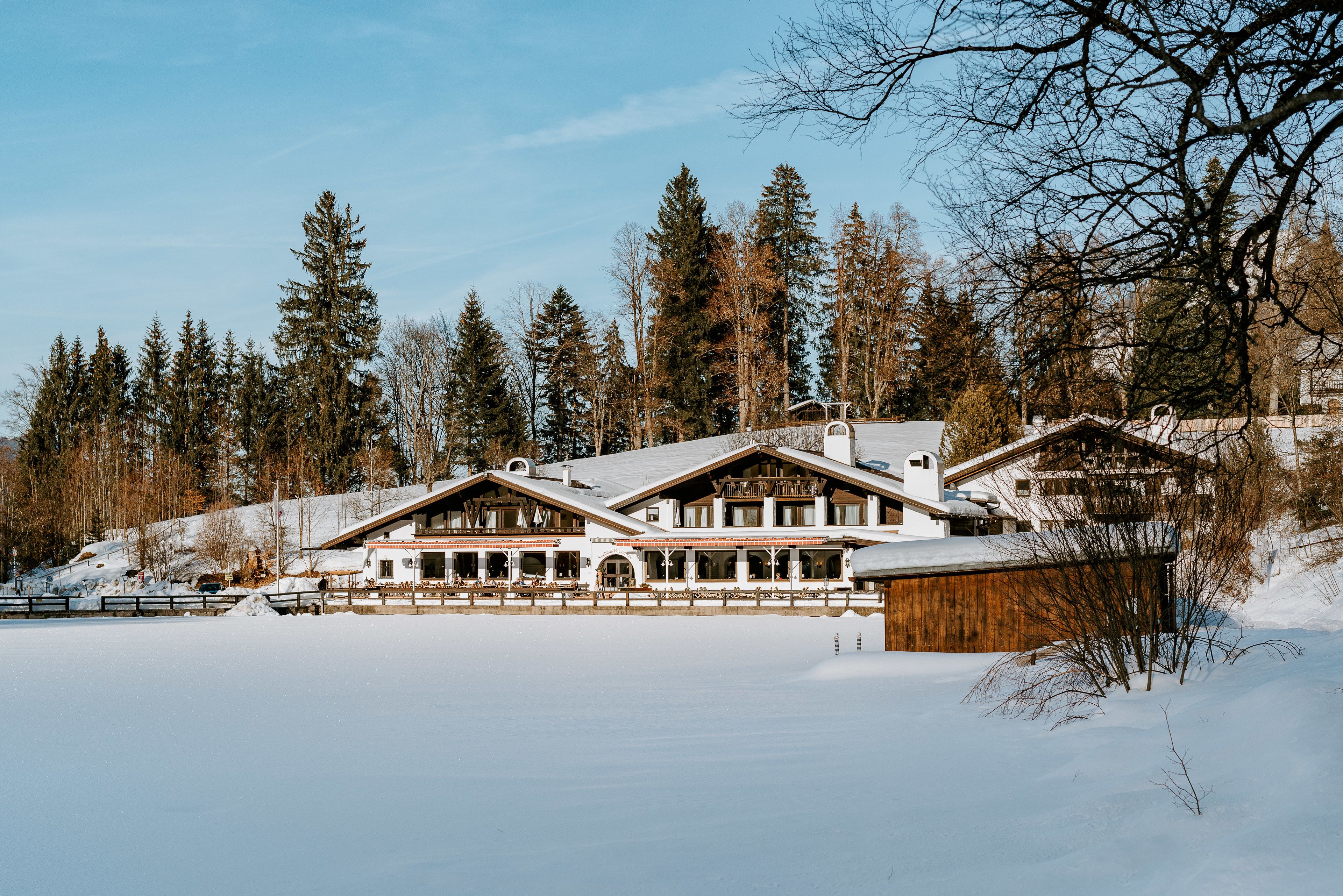 A large lodge with multiple guest rooms, a dining area, and a wooden barn.