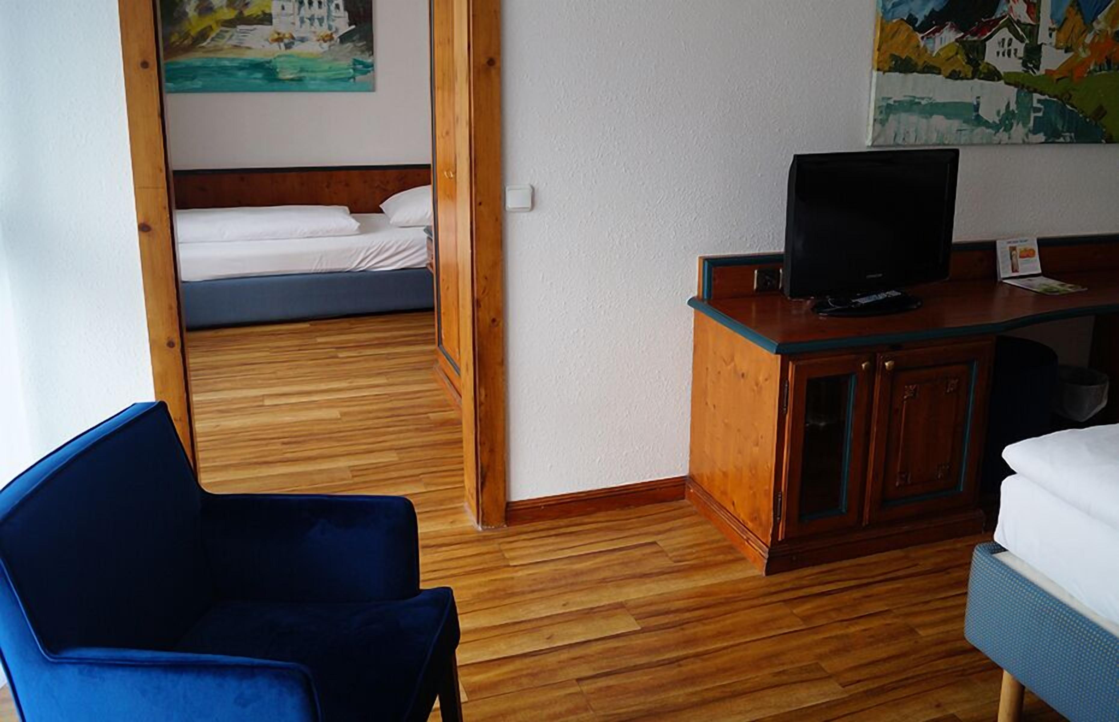 Una habitación con una cama, un escritorio con un ordenador y una silla.