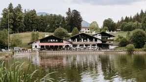 A lakeside building with multiple balconies and a dining area. - Riessersee Hotel (Garmisch-Partenkirchen)