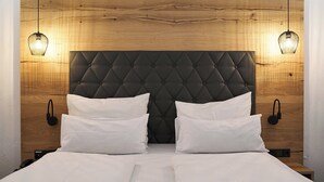 A bed with a tufted headboard, two bedside tables, and two wall-mounted lamps.
