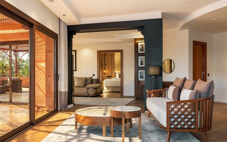 A spacious living area with a sofa, coffee table, and a view through a glass door to an outdoor patio.