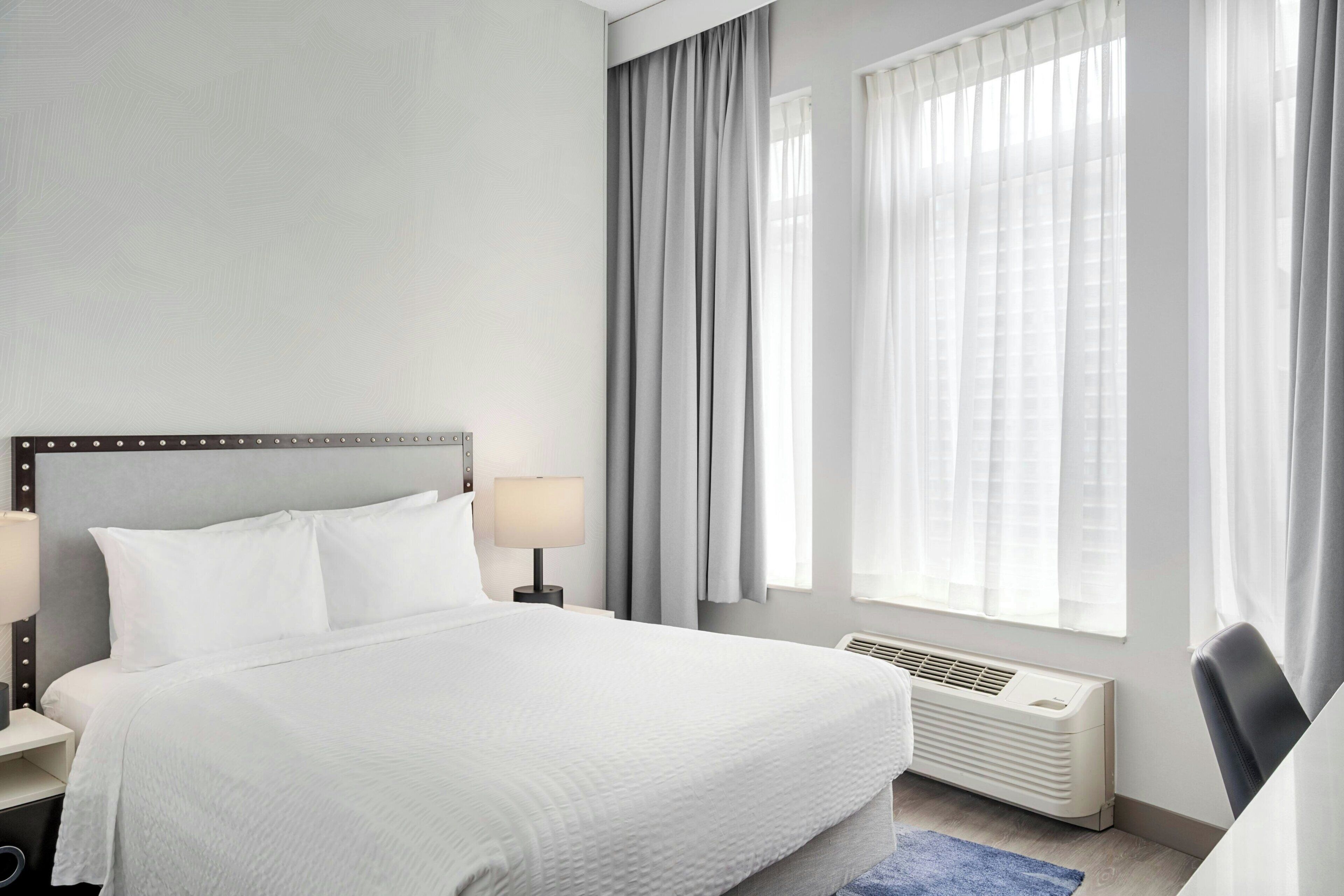 Habitación, 1 cama Queen size | Camas con pillow-top, escritorio y cortinas blackout 