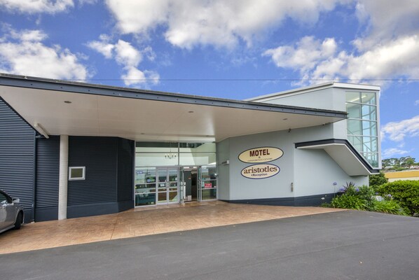 A modern motel with a glass entrance and a sign for 'Motel & Conference Centre' and 'Aristotle's Reception'. - Aristotles North Shore (Auckland)